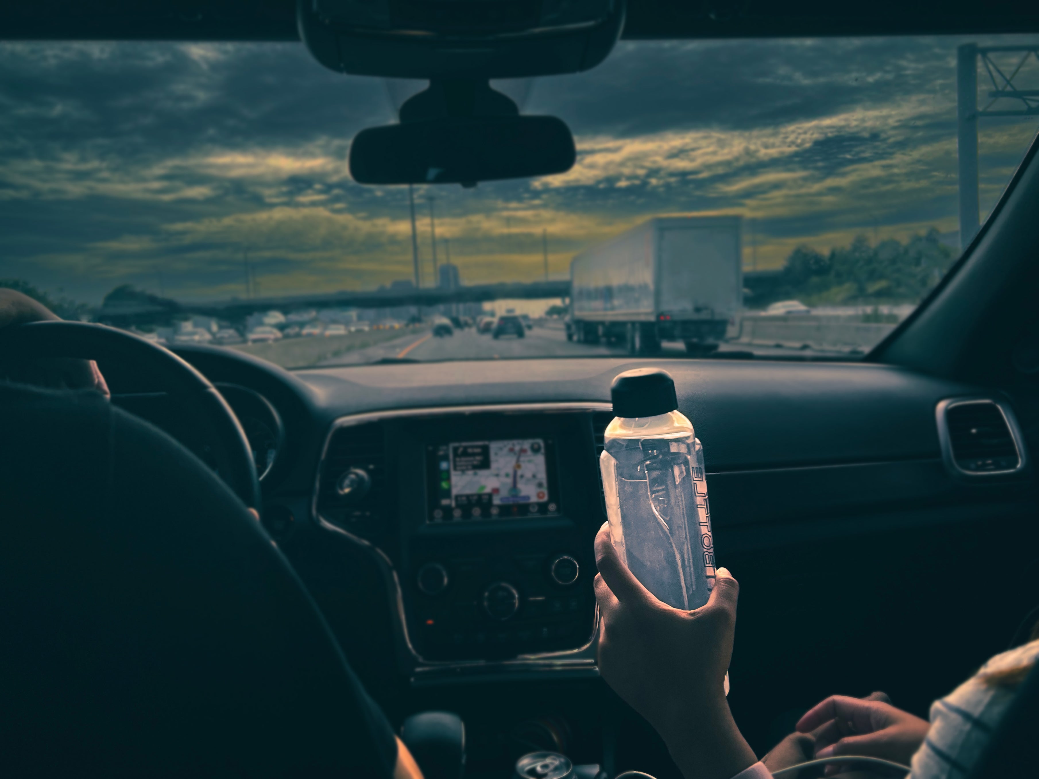 Smartbottle -Man driving beside a Woman Holding Smartbottle 